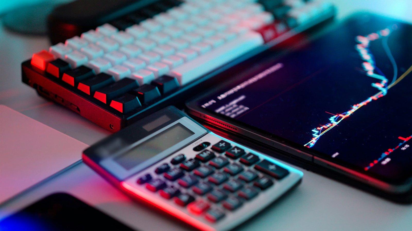 A laptop computer sitting on top of a desk next to a calculator